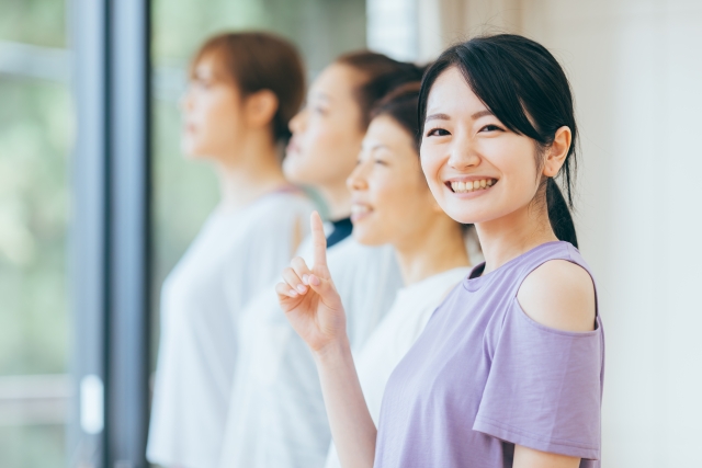 人差し指を立てている笑顔の女性